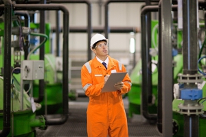 Engineer inspecting machinery in factory --- Image by © Image Source/Corbis